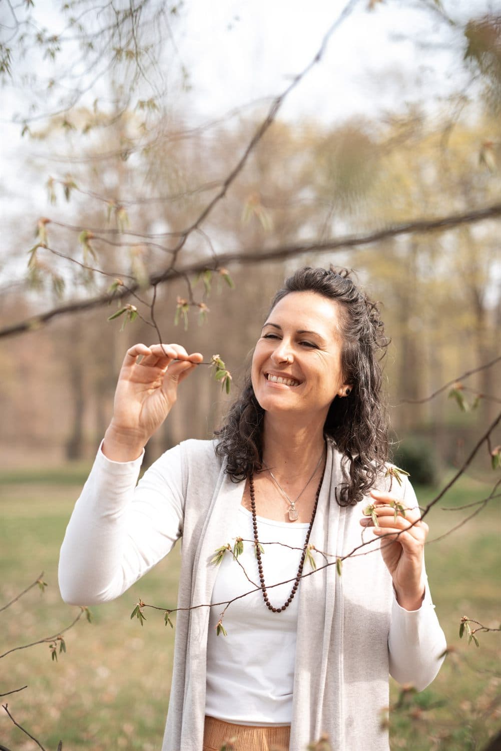 Romy Schwarz lacht mit geschlossenen Augen unter einem Baum